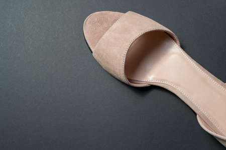 women's shoes of beige color on a black background. shoes removed from the top. shoes are at an angle relative to the horizonの写真素材