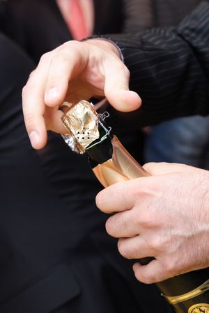 The man's hands opening a bottle of champagne.の写真素材