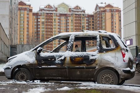 The burnt down car in snow. The second day after a fire.の写真素材