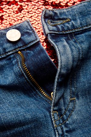 Unbuttoned jeans on a red fabric