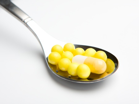 Spoonful of pills isolated on white backgroundの写真素材