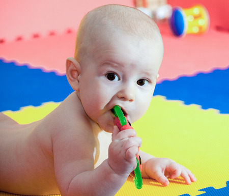 portrait of the nice child with brown eyes who plays on a developing rugの写真素材