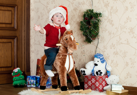 Baby boy playing with a rocking horseの写真素材