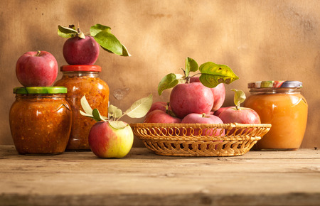 Jam made from apples in glass jars, apples in a wicker basketの写真素材