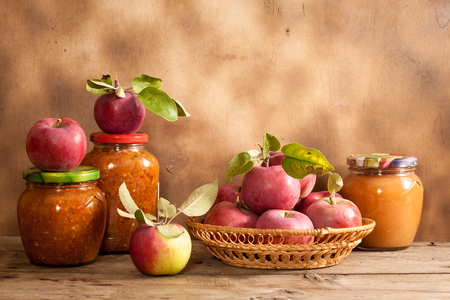 Jam made from apples in glass jars, apples in a wicker basketの写真素材