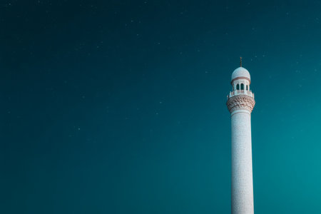 A tall minaret stands majestically against a deep blue sky, illuminated by the soft glow of distant stars. Its intricate patterns reflect centuries of architectural beauty and cultural significance.の素材