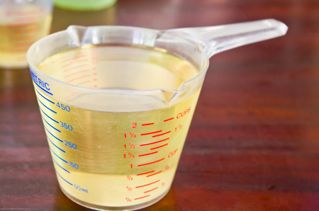 oil in measuring cup on table in kitchenの写真素材