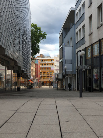ngs on both sides. In the distance, colorful buildings and a tree. The tiled street exudes calm and quiet.の写真素材