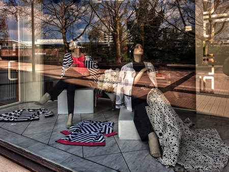 Shop window with two mannequins in glass reflecting the city. High quality photoの写真素材