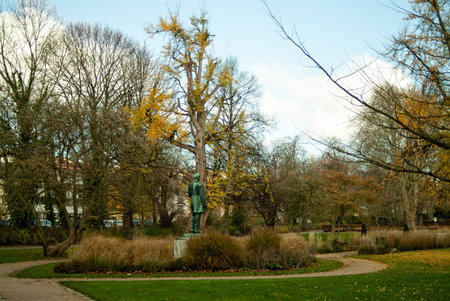 In the autumn city park in the morning, there are few people, or rather, there are no people at all, only yellow foliage and a non-working fountainの写真素材
