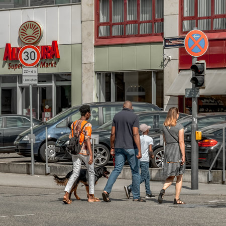 Pforzheim Germany Mai 25, 2018  Urban Pedestrians Crossing Busy City Intersection, Three Adults Walking Together, Casual Attire, Backpacks And Toteのeditorial素材