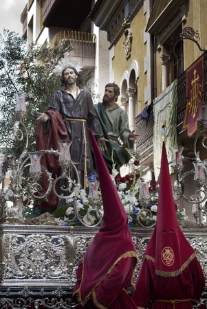 Couple of penitents with a Holy Week image during a procession in Jumilla  Spain の写真素材