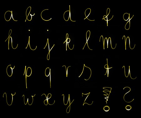 Flourescent letters of the alphabet in bright yellow neon colorの写真素材