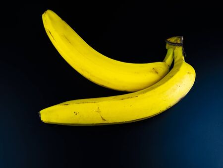 Yellow bananas on a black background. Place for text.の写真素材