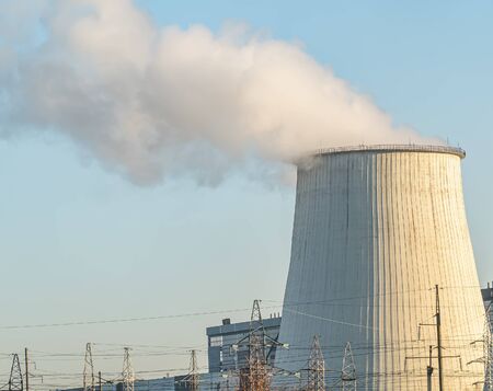 Smokestack of a thermal power plant against a blue sky. Technology. Place for text. Background...