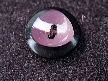 Colored button on a woolen cloth coat. Tailoring. Place for text. Background image.