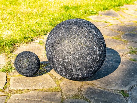 Balls of thread on a green flowerbed of a public park. Decor flower beds. Background image. Place for text. Hand mei. Handwork. Decoration.の写真素材