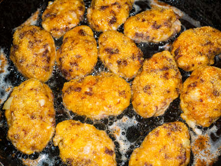 Meat cutlets are fried in a skillet.