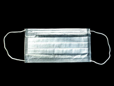 White medical face mask on a black background. Coronavirus. Pandemic. Epidemic. Protective face mask...