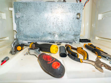 Working tool in the freezer of the refrigerator. Master tool for refrigerator repair. Refrigeration...