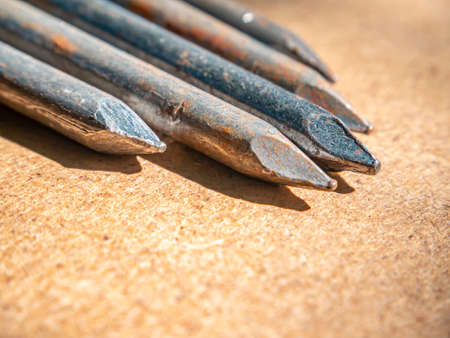 Iron nails on a wooden table macro photo. Nail head. Sharp tip. Joiner's material. Wooden background. Macro photography. Background image. Place for text.の写真素材