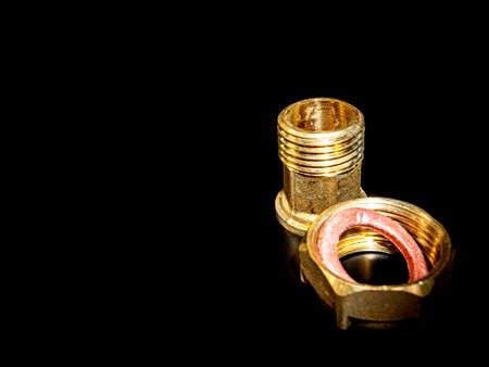 Nuts with gaskets for connecting water pipes. Black background. Plumbing equipment. Plumbing repair....