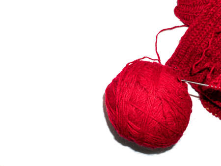 A ball of thread for knitting clothes. White background. Handmade. Burgundy woolen threads for...