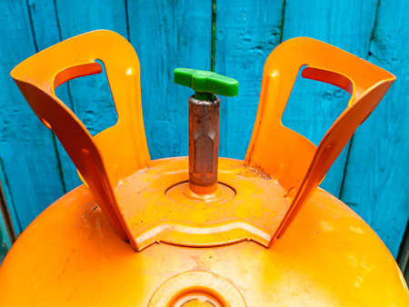 Refrigerant cylinder for the repair of refrigeration equipment. Orange bottle with freon....