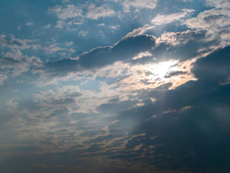 Orange rays of sunset through storm clouds. Yellow evening dawn. Morning yellow sunny dawn. Clouds...