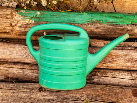 Green plastic watering can for plants and flowers. Watering can for the garden. Water the plants and flowers. Pour the vegetable garden. Gardening. Work tool. Gardener's tool. Place for text.の写真素材