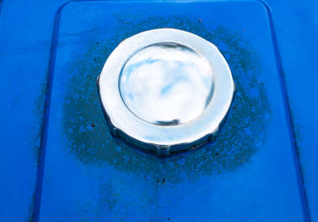 Nickel plated fuel tank cap in blue car color. Truck fuel tank cap. Place of the gulf of gasoline into the vehicle. Refueling a diesel agricultural tractor. Background image. Place for your text.の写真素材