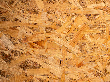 The structured texture of the wood fiber panel. Chipboard. Wood board texture. Timber processing...