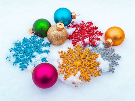 Christmas tree toys colored balls and snowflakes on white snow. Christmas holidays. New Year. Loose winter snow. New Years holidays. Winter vacation. Place for text. Greeting card.の写真素材