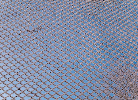 Metal mesh in white frosty frost in winter. Fence mesh. White snow. Frosty frost. Winter season....