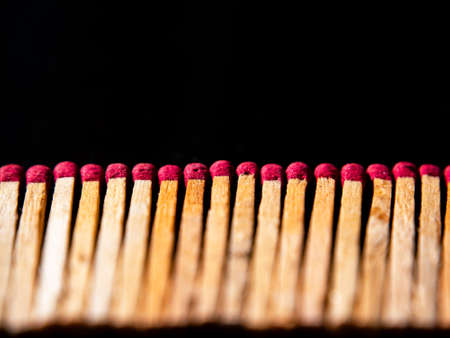 Wooden matches with red sulfur heads on a black background.の写真素材
