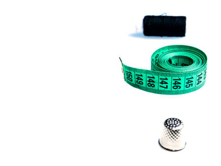 Tailor centimeter and sewing accessories on a white background. Seamstress centimeter. Meter ruler. Inches and centimeters. Cutting and sewing. Olezhda repair and sewing. Spool of thread.の写真素材