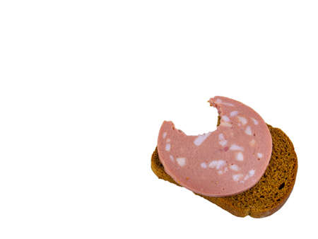 Bitten black bread sandwich with pork sausage and lard on a white plate. Black bread. Meat sausage. Pork fat. Pork product. Fatty food. Not vegetarian food. Meat dish. Home kitchen. White background.の写真素材