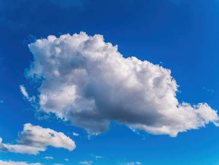 White cloud against blue sky in sunlight.の写真素材
