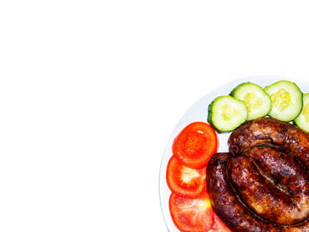 Smoked meat sausage on a plate with tomatoes and cucumbers.の写真素材