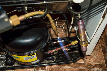 Oxygen gas welding during the repair of a refrigerator unit. Oxygen welding. Refrigeration unit...