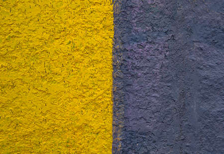 The surface is painted in yellow and black. Paint on a concrete wall. Texture of a colored surface. Black and yellow color. background image. Template for text. Two vertical halves.の写真素材