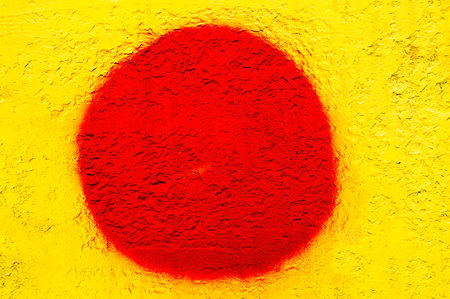 Red round spot of paint on a yellow background.の写真素材