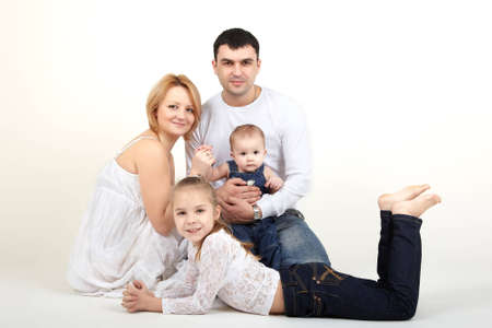 Beautiful family portrait lying on the floor - isolated over a white background 
