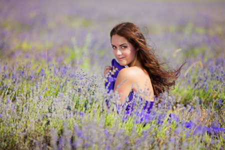 Close up portrait of a beautiful woman on a lavender field at summerの写真素材