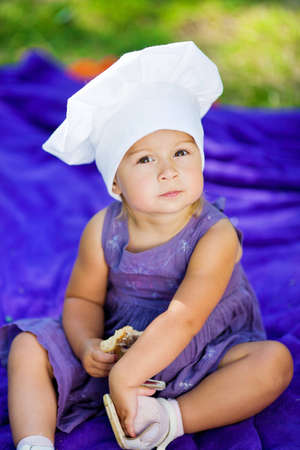 Close up portrait of a cute girl wearing a chef hat の写真素材
