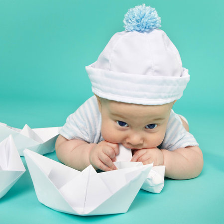 Portrait of cute little boy plays with toy ship. Sea theme の写真素材