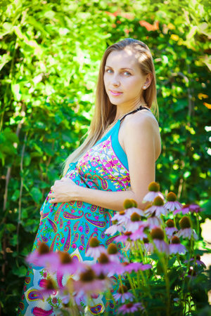 Young beautiful pregnant woman relaxing in the parkの写真素材