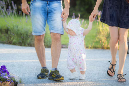 Father, mother and child daughter spending time outdoor on a summer day.の写真素材