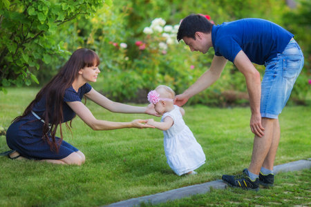 Mother and baby girl. Happy woman and child playing outdoors.の写真素材
