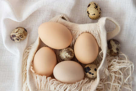 Chicken eggs in a string bag on white background, selective focus. Happy easter background.の写真素材